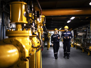 Industry workers checking the pipes for leaks and informing about the situation with Agnet