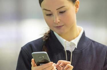 Female security officer uses a smartphone Female security officer uses a smartphone