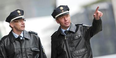 Two German police officers one pointing with finger Two German police officers one pointing with finger