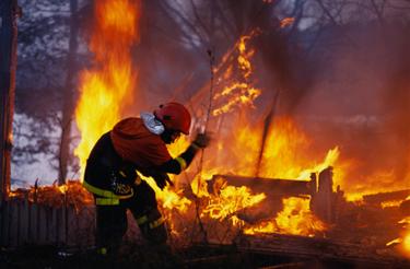 Firefighter in front of a huge fire Firefighter in front of a huge fire
