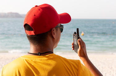 Lifeguard holding a robust mobile device Lifeguard holding a robust mobile device