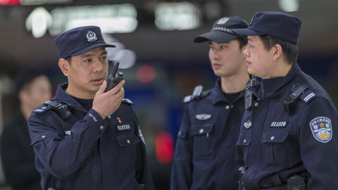 TETRA - Guangzhou police speaking to a device with other two standing next to him