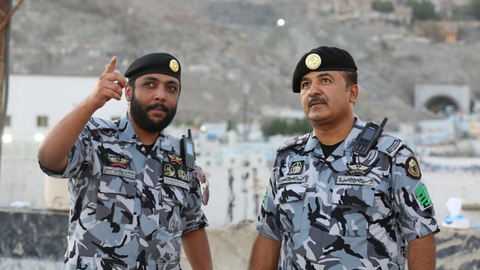 The Saudi radio communications - 2 saudi officers with tetra devices on the shoulder