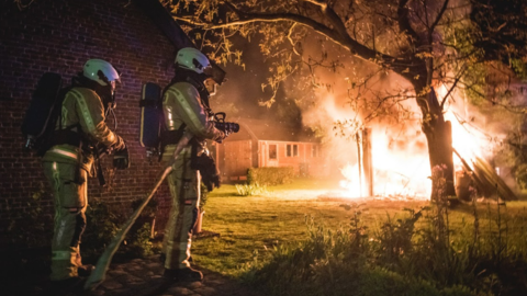 Firemen - 2 firemen fighting a forest fire at night