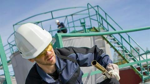 Industrial user in front of oil containers