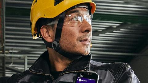 Industry worker uses external PTT with smartphone and Agnet