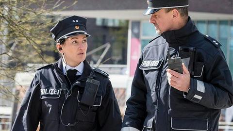 Two German police officers walking and Tactilon Dabat in hand