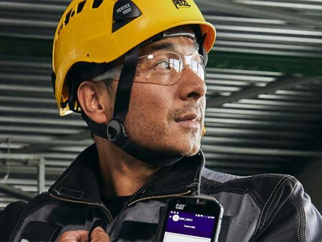 Industry worker uses external PTT with smartphone and Agnet