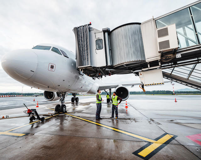 Ground handlers collaborating under a Airbus A320 during turnaround Ground handlers collaborating under a Airbus A320 during turnaround