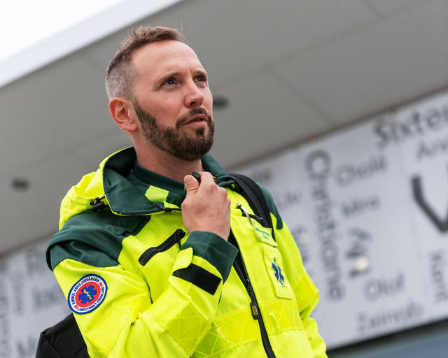 Paramedic talking to a ear peace including a ptt mic Paramedic talking to a ear peace including a ptt mic