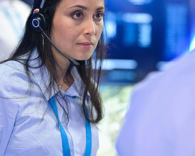 Control room operator discussing with a colleague Control room operator discussing with a colleague