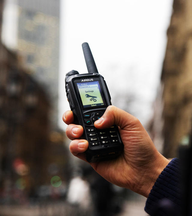 Police officer scrolling the menu of a TH9 TETRA terminal