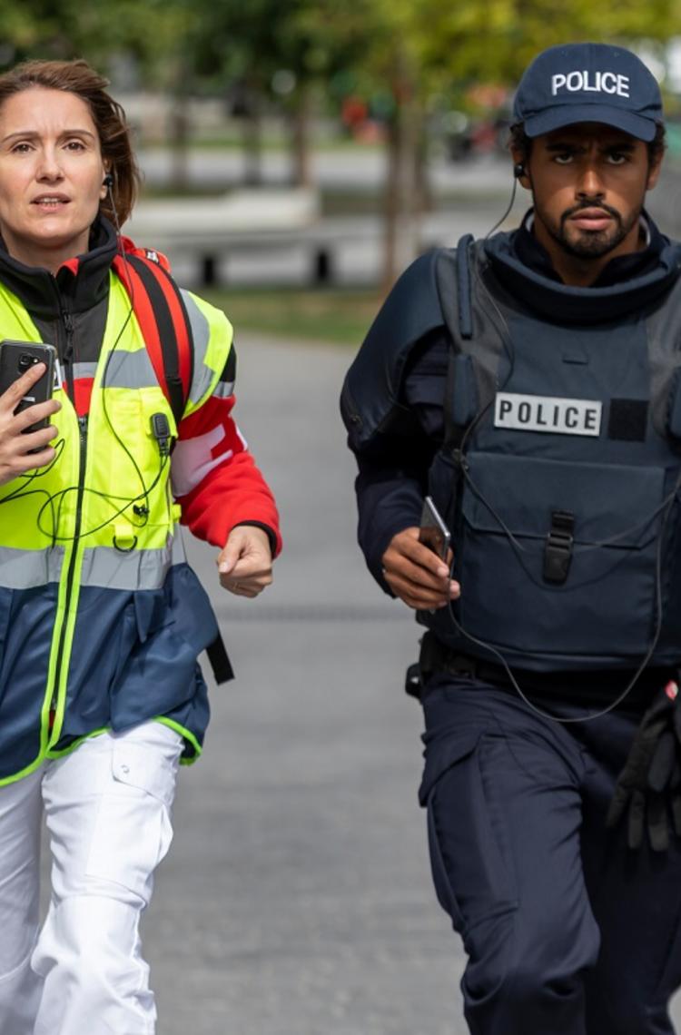 paramedic female and police male running for an emergency with their phones in hands paramedic female and police male running for an emergency with their phones in hands
