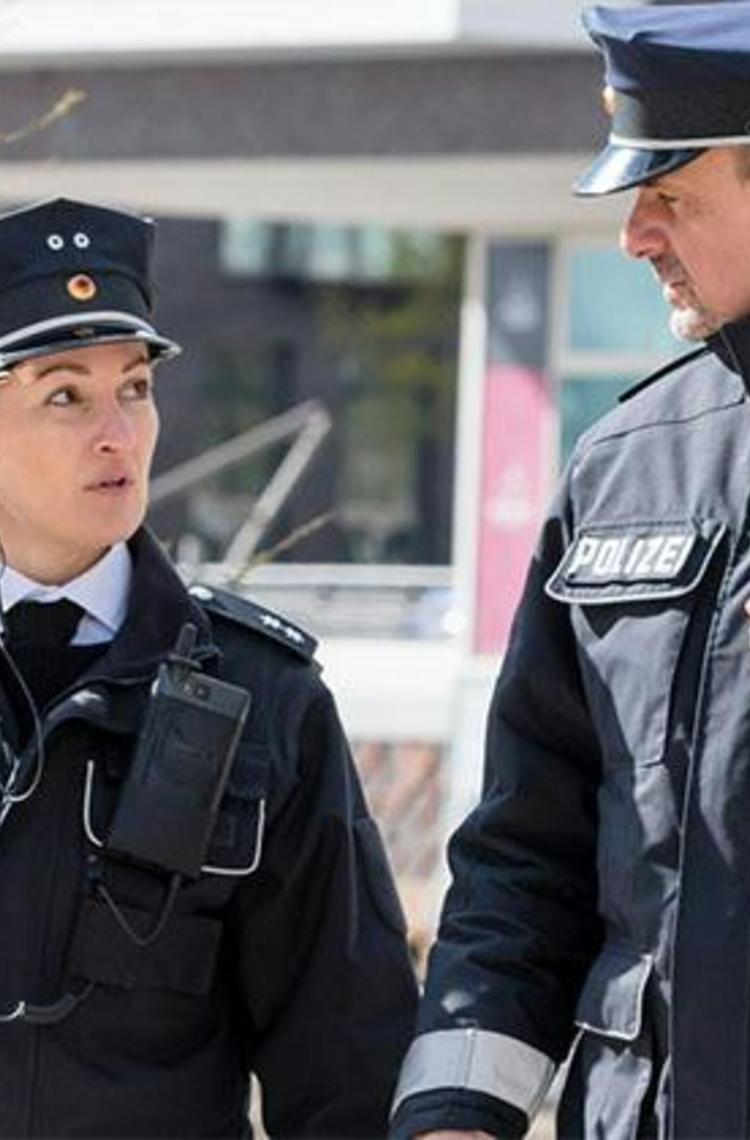 Two German police officers walking and Tactilon Dabat in hand Two German police officers walking and Tactilon Dabat in hand