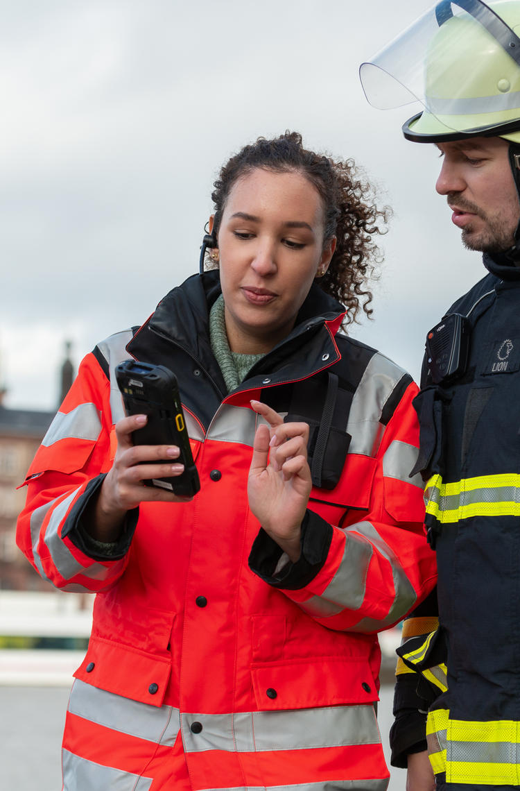 two_public_safety_firefighters_woman_holding_a_device.jpg