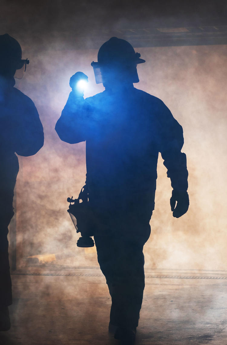 Firemen wandering in the smoke with lights Firemen wandering in the smoke with lights