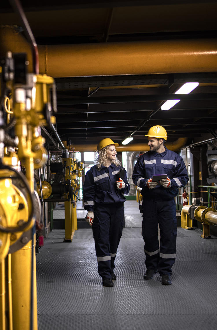 two workers investigating if everything is ok at a gas powerplant