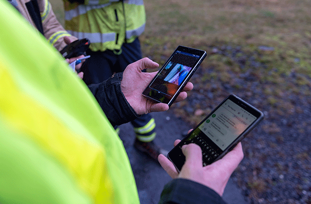 Close view on Fireman holding two smartphones in his hands showing Agnet