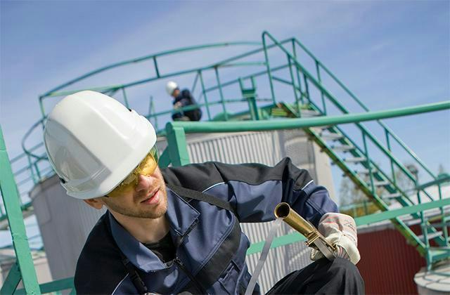Industrial user in front of oil containers