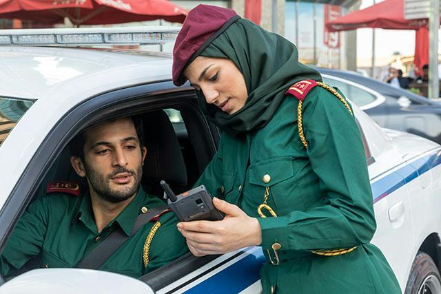 Police in a car and second police outside both looking at Tactilon-Dabat