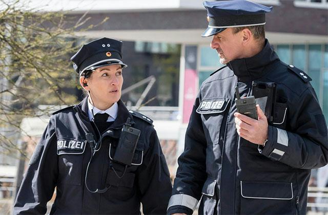 Two German police officers walking and Tactilon Dabat in hand