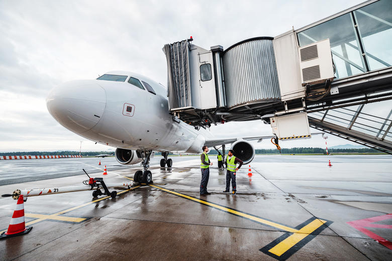 Ground handlers collaborating under a Airbus A320 during turnaround