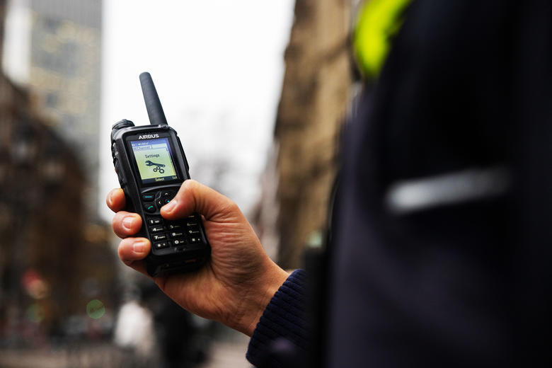 Police officer scrolling the menu of a TH9 TETRA terminal