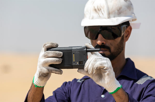 Field worker in a desert taking a photo with Tactilon Dabat