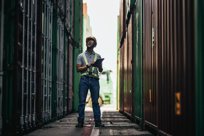 Dock worker checking the cargo and informing about it with Agnet on a tablet