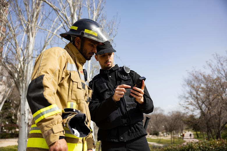 Fireman and security officer discussing a mission usign Agnet and a Zebra smartphone