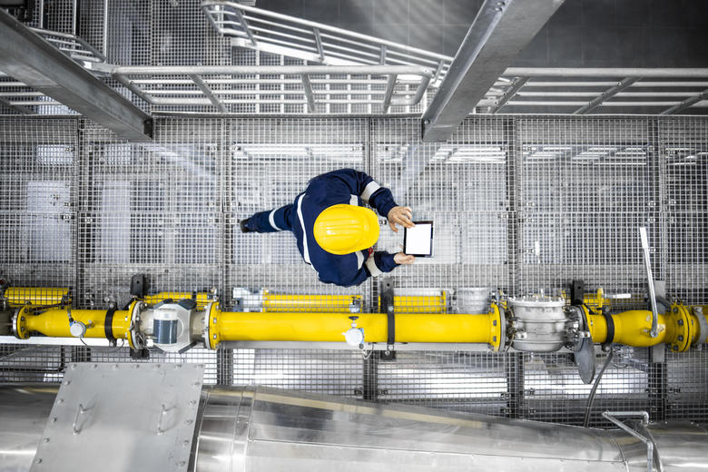 Industry worker holding a device in a manufacturing facility